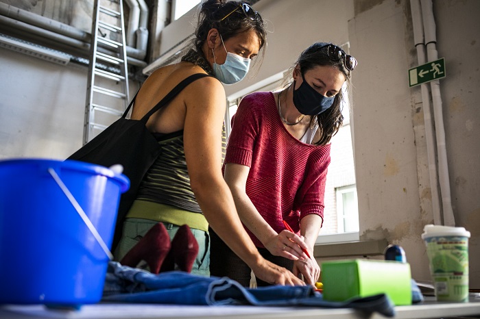 Zwei Frauen beugen sich über einen Tisch um etwas zu betrachten