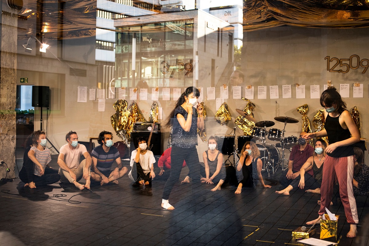 Durch eine Scheibe sieht man Tanzende in einem Ladenlokal